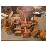 Nine Longaberger baskets as shown. Assorted basket group with woven wood construction and traditional Longaberger styling, suitable for collecting, display, storage, gift baskets, or resale.