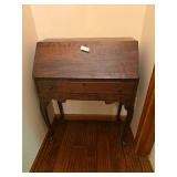 Antique wood desk with compact form and traditional styling. Measures approximately 38 in. tall x 30 in. wide x 16 in. deep. Suitable for use as a writing desk, accent piece, or decorative furniture i