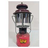 Vintage KampLite No. KFL-2 pressure lantern with red painted fount, dark maroon ventilator, clear glass globe and black wire frame/bail assembly. Shows paint loss, oxidation and general age-related we