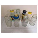Group of Planters Mr. Peanut glass jars and containers in assorted sizes and styles, including embossed and labeled examples. Mixed lids and condition as shown.