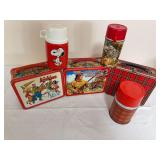 Group of vintage lunch boxes and thermoses including The Archies, Fess Parker/Daniel Boone and plaid lunch boxes, plus Snoopy and other character/design thermoses as shown. Shows general age-related w
