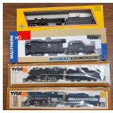 Four boxed model trains including Pennsylvania steam locomotive and tender, Milwaukee Road electric locomotive and tender, Tyco Chattanooga No. 638 steam locomotive and tender, and Tyco Royal Blue No.