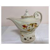 Hall Autumn Leaf Aladdin-form lidded teapot with matching ceramic warmer/base and removable perforated infuser, decorated with gold trim. Teapot features the distinctive sweeping spout and curled hand