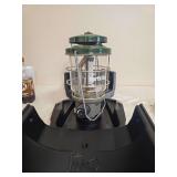 Coleman Model 2000-043C NorthStar Lantern. Green NorthStar pressure lantern with clear Coleman globe, protective wire cage, large control knob and molded black carrying base/case; shows general age-re