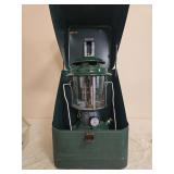 Coleman Model 220F Lantern with Metal Carrying Case – Marked 6/72. Green double-mantle pressure lantern with matching green ventilator, clear globe and wire bail handle, housed in a green metal carr