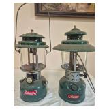 Coleman Models 220H & 228E Lanterns – Marked 5/73 & 3/53. Green double-mantle pressure lanterns with clear globes and wire bail handles, including the wide-ventilator 228E; shows paint wear, oxidati