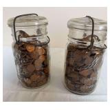 Two Ball Ideal wire-bail glass jars filled with unsearched U.S. pennies; cataloger noted seeing some wheat cents. Contents have not been sorted or counted.