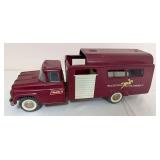 Vintage Buddy L pressed-steel Riding Academy horse transport truck in maroon with white sliding side door, horse graphics and whitewall-style tires. Shows general age-related wear.