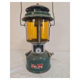 Coleman Model 220J Double-Mantle Lantern – Marked 8/77. Green painted fount with matching green ventilator, amber Coleman globe and wire bail handle; shows paint wear, decal loss, oxidation and age-