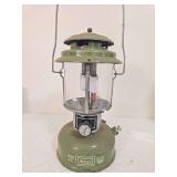 Sears Model 72325-1 pressure lantern marked 5/77, with green painted fount, matching green ventilator, clear Coleman globe and wire bail handle. Shows paint loss, oxidation and age-related wear.