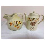 Two Hall pieces including a large Autumn Leaf pitcher with bulbous body and gold trim, and a lidded Jewel Tea Co. 100th Anniversary teapot marked “1899–1999” with Autumn Leaf decoration. Anniver
