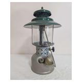 Coleman Model 228D pressure lantern with silver-tone fount, green porcelain ventilator, clear globe and wire bail frame; marked B/49. Includes chained cap/funnel-style accessory as shown and shows oxi