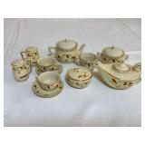 Miniature Hall/China Specialties Autumn Leaf tea set including teapot, lidded sugar bowl, creamer, two cups with saucers, lidded covered dish, and handled salt and pepper shakers, all with cream glaze