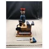 Wooden decorative piece of train and conductor.
