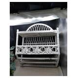 White wicker shelf with artificial pink rose in