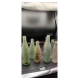 7 older Coca Cola Bottles needs. cleaned up