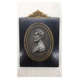 Abraham Lincoln plaque mounted on wood.