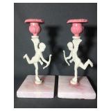 Pair of metal Cupid candle holders on pink and