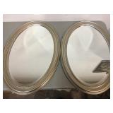 Pair of silver colored oval wall mirrors