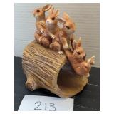 Ceramic bunnies on a log garden decor