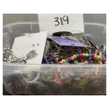 Small container full of mixed jewelry