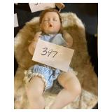 Ceramic sleeping baby doll on rug