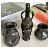 Two Black Cermaic Vessels along with a Empty Wine