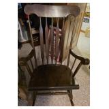 A rocking chair with some signs of wear.
