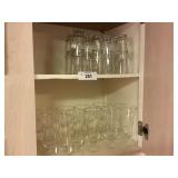 Kitchen cabinet full of vintage glasses water +