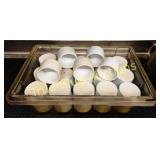 Plastic condiment cups in a clear storage containe