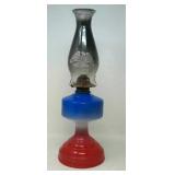 Antique oil lamp painted red, white and blue.