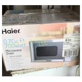 0. 7 CU ft. 700 W Haier white microwave oven.