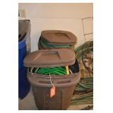 2 garbage cans with assorted garden hose