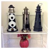(3) Metal Lighthouses and Floral Arrangement