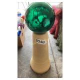 Concrete pedestal with green gazing ball