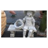 Concrete girl on bench yard art