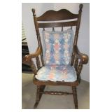 Vintage wood rocking chair with seat cushions.