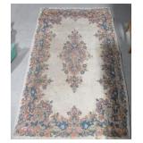 Area rug. Measures 60" x 36". Shows wear.