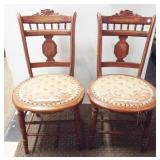 A pair of matching wood dining chairs with ornate