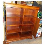 Cherry wood colored eight section book shelf.