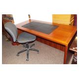 Cherry wood desk with rolling office chairs.