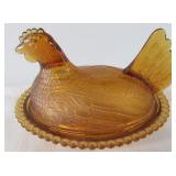 Amber glass hen on the nest. Measures 7" long.