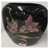 Black vase with purple irises. Measures 8.5"
