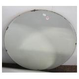 Vintage round wall mirror with beveled edges.