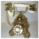 Heavy metal rotary desk phone with ornate design.