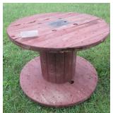 Wood spool made into table. Shows some wear.