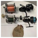 Lot of 4 fishing reels and advertising bag