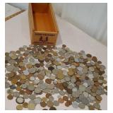 Box of foreign money coins in wooden advertising
