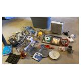 Grey tub of power cords, picture frames, fan,