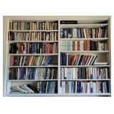 Books on two white bookshelves over the desk